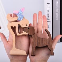 a person holding two wooden animals in their hands