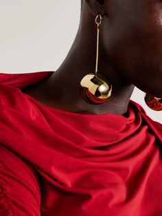 Jacquemus' sculptural 'Nodo' earrings feature spherical drops that are hollowed out to ensure a lightweight feel. They're cast from gold-plated brass with a mirror-like shine and have slim, structured bars that dangle from teardrop-shaped posts. Floral Dresses Short, Exclusive Dress, Earrings In Gold, Fashion Jewelry Earrings, Fine Jewelry Designers, Contemporary Jewellery, Bag Dress, Gold Plated Earrings, Beauty Accessories