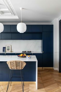 a modern kitchen with blue cabinets and white counter tops, an island in the center