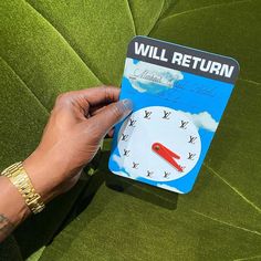 a person is holding up a card with a clock on it