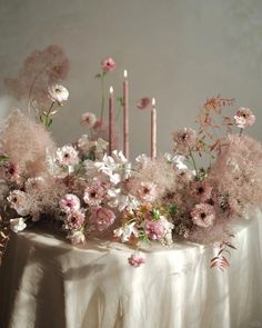 a table topped with pink flowers and candles