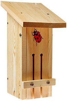 a wooden birdhouse with a ladybug painted on the side