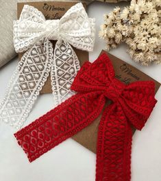 three red and white bows are sitting next to each other on top of a card