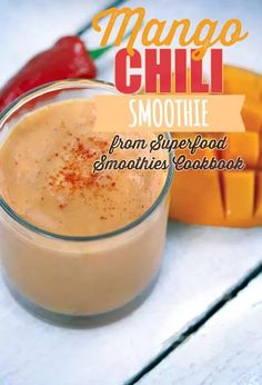 a smoothie in a glass with mango and chili on the side