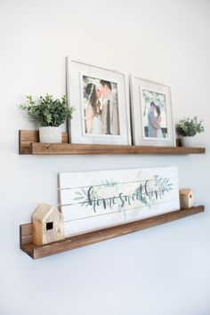 two wooden shelves with pictures and plants on them