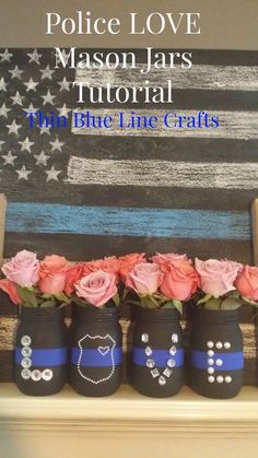 four mason jars decorated with blue line crafts and pink roses in front of an american flag