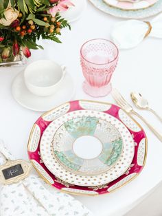 the table is set with dishes and place settings