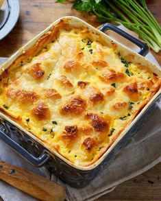 a casserole dish with cheese and bread in it on a napkin next to utensils