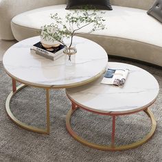 two tables sitting on top of a carpeted floor next to a couch and table