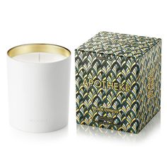 an empty candle sitting next to a box on a white surface with the words apothheke printed on it