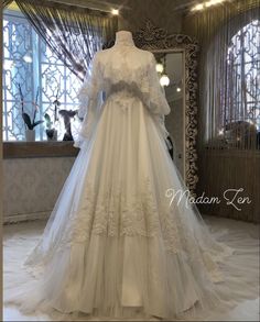 a white wedding dress on display in front of a mirror