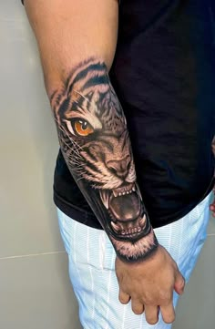 a man's arm with a tiger tattoo on it and an orange eye in the center