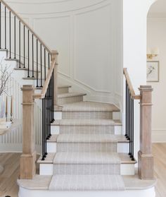 a staircase with white walls and black railings