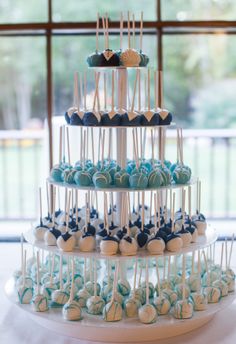 a three tiered cake with blue and white candies