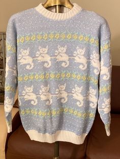 1980s vintage cat floral print sweater by Arielle. It's blue and white with metallic sparkly thread and yellow flowers with green leaves. Excellent condition. So cute. I'm suggesting for a size small to medium. Marking as a medium. It could fit some size large. See measurements. Bust is just under 21 inches. The bottom waistband is 16 inches across (32 inches) stretches to 20 to 21 inches. Shoulders are about 22 inches. Arms are about 28 inches. Sweater is about 25.7 inches long. Kawaii Fairy, Floral Print Sweater, Cat Sweater, 80s Sweater, Style Inspiration Winter, Mohair Sweater, Pullover Sweater Women, Vintage Cat, 80s Vintage