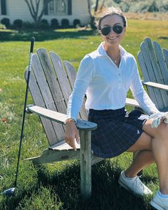 a woman sitting on top of a wooden bench