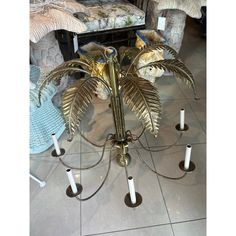 a metal chandelier with four candles on it in a room filled with furniture