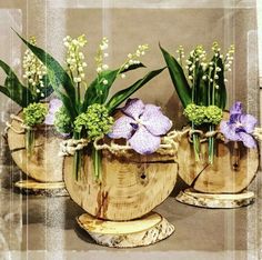 three wooden planters filled with purple flowers and greenery sitting on top of a table