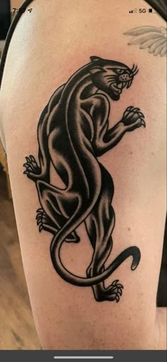 a black and white tattoo on the back of a woman's arm, with a lizard