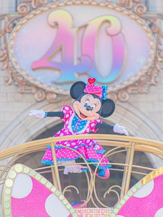 minnie mouse on top of a carousel in front of the entrance to disneyland's 20th anniversary celebration