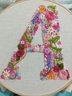 an embroidered letter with flowers on it