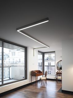 an empty room with wooden floors and large windows