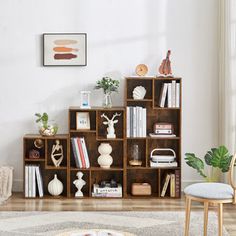 a living room filled with lots of furniture and bookshelves next to a window