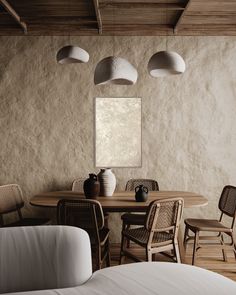 a dining table with four chairs and two vases on it