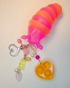 a pink and orange plastic object on a white surface next to a pair of scissors