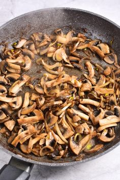 a pan filled with mushrooms on top of a table