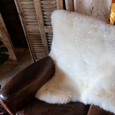 a brown and white chair sitting in front of a fireplace