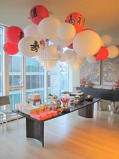 a long table with lots of paper lanterns hanging from it