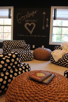 a living room with polka dot furniture and a chalkboard on the wall behind it