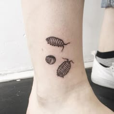 a black and white photo of a woman's foot with three leaf tattoos on it