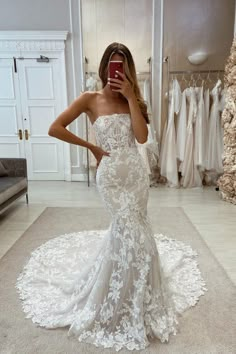 a woman is taking a selfie in her wedding dress while looking into the mirror