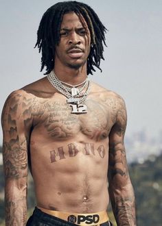 a shirtless man with tattoos on his chest and neck is posing for the camera