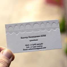 a person holding up a business card in their hand