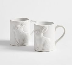 two white ceramic mugs with rabbits on them