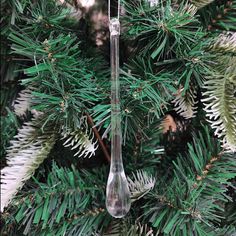 an ornament hanging from a christmas tree with pine needles in the foreground