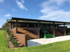 there is a large pile of dirt in front of a building that has a tractor on it