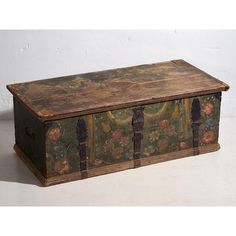 an old wooden trunk with floral paintings on it's sides and two doors at the top