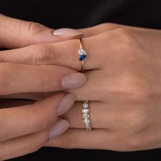 a woman's hand holding an engagement ring with two diamonds on it and a diamond band