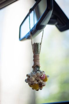 a bunch of flowers hanging from the side of a car mirror in front of a rear view mirror