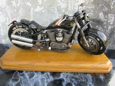 a model motorcycle is sitting on a wooden stand