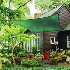 a house with a green awning over the front yard and garden area in front of it