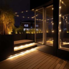 some lights that are on the side of a building at night with stairs lit up