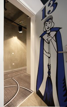 a drawing of a woman with a broom in her hand on the wall next to an elevator