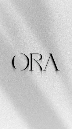 the word ora is written in black on a white background with shadows from it