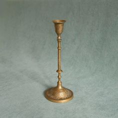 an antique brass candle holder on a blue background