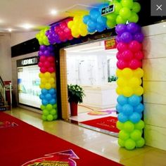 an entrance to a store decorated with balloons